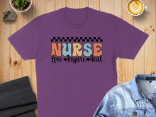 Load image into Gallery viewer, Purple t-shirt with "Nurse Love Inspire Heal" text and checkered border.