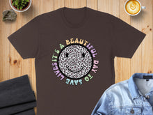 Load image into Gallery viewer, Brown t-shirt with a pastel smiley face graphic that says "it's a beautiful day to save lives".