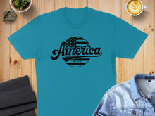 Load image into Gallery viewer, Teal t-shirt with "America Est. 1776" text and American flag circle graphic.