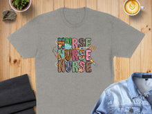 Load image into Gallery viewer, Gray t-shirt with colorful "NURSE NURSE" text and medical icons.