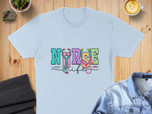 Load image into Gallery viewer, Light blue t-shirt with "Nurse Life" text and medical icons.