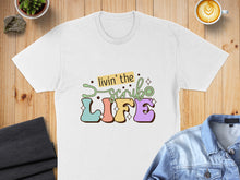 Load image into Gallery viewer, White t-shirt with colorful "Livin' the Life" text and medical icons.