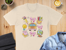 Load image into Gallery viewer, T-shirt with colorful school supplies: lightbulb, globe, books, crayons, and pencil.