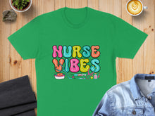 Load image into Gallery viewer, Green t-shirt with colorful "Nurse Vibes" text and medical icons.