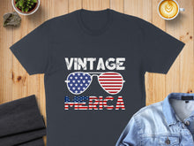 Load image into Gallery viewer, Dark t-shirt with "VINTAGE MERICA" text and American flag sunglasses.