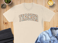 Load image into Gallery viewer, Cream t-shirt with floral "TEACHER" text design.
