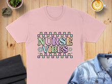 Load image into Gallery viewer, Pink t-shirt with "Nurse Vibes" text in colorful pastel blocks and flowers.