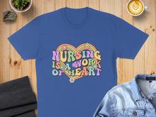 Load image into Gallery viewer, Blue t-shirt with "Nursing is a work of heart" text and colorful floral accents.