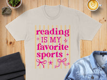 Load image into Gallery viewer, Beige t-shirt with pink text "Reading is my favorite sports" and bows.