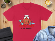Load image into Gallery viewer, Red t-shirt with a Halloween nurse pumpkin graphic and text.