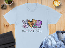 Load image into Gallery viewer, Light blue t-shirt with "Peace Love Radiology" graphic and medical symbols.