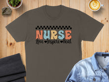 Load image into Gallery viewer, Brown t-shirt with "Nurse Love Inspire Heal" graphic and checkerboard detail.