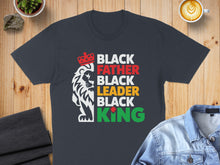 Load image into Gallery viewer, Dark t-shirt with red, white, yellow, and green text and a lion graphic.