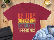 Load image into Gallery viewer, Maroon t-shirt with colorful text "BE LIKE SUBTRACTION AND MAKE A DIFFERENCE".