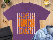 Load image into Gallery viewer, Purple t-shirt with orange text reading "Lunch Day" and a bow.