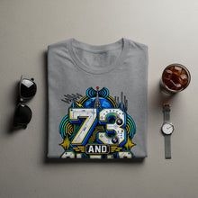 Load image into Gallery viewer, Grey t-shirt with graphic design of "73 AND" with radio tower and gauges.