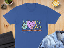 Load image into Gallery viewer, Blue t-shirt with "Peace Love Nursing" text, peace sign, stethoscope, and syringe.