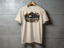Load image into Gallery viewer, Cream t-shirt with graphic of radio equipment, measuring tools, and text "Measure Twice Tune Once".