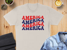 Load image into Gallery viewer, Cream t-shirt with "AMERICA AMERICA AMERICA" in red and blue text.