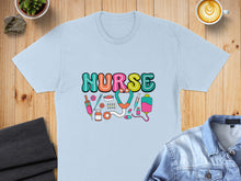 Load image into Gallery viewer, Light blue t-shirt with colorful "NURSE" text and medical icons.