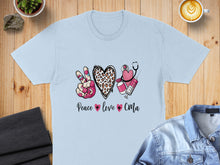 Load image into Gallery viewer, Light blue t-shirt with peace sign, heart, stethoscope, and syringe graphic, "Peace love CMA" text.