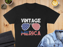 Load image into Gallery viewer, Black t-shirt with "VINTAGE AMERICA" text and American flag sunglasses.
