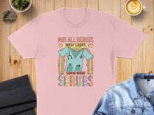 Load image into Gallery viewer, Pink t-shirt with "Not all heroes wear capes, some wear scrubs" and scrub uniform graphic.