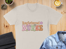 Load image into Gallery viewer, Beige t-shirt with "Registered Nurse" text in pastel, retro lettering with floral accents.