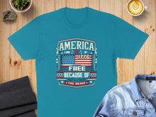 Load image into Gallery viewer, Turquoise t-shirt with "America, Land of the Free Because of the Brave, 1776" design.