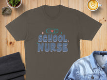 Load image into Gallery viewer, Brown t-shirt with "SCHOOL NURSE" text and a heart with a bandage.