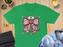 Load image into Gallery viewer, Green t-shirt with a pink bow graphic featuring a stethoscope and nurse hat.