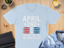 Load image into Gallery viewer, Light blue t-shirt with "APRIL 2ND LIBERATION DAY IN AMERICA!" and American flag design.