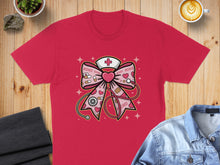 Load image into Gallery viewer, Red t-shirt featuring a pink bow with medical and XOXO motifs.