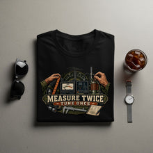 Load image into Gallery viewer, Black t-shirt with "MEASURE TWICE TUNE ONCE" design featuring radio equipment.