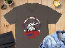 Load image into Gallery viewer, Gray t-shirt with eagle and USA flag graphic on wooden background.