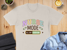 Load image into Gallery viewer, Light beige t-shirt with "Nurse Mode All Day Every Day" text and band-aids.