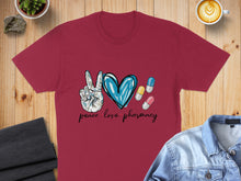 Load image into Gallery viewer, Burgundy t-shirt with peace, love, pharmacy text and heart with pills.