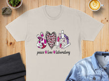 Load image into Gallery viewer, Peace, love, laboratory text with medical and science graphics on a beige t-shirt.