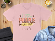 Load image into Gallery viewer, Light pink t-shirt with "I stab people for a living #nurselife" text.