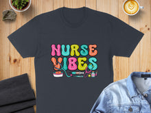 Load image into Gallery viewer, Nurse Vibes colorful text with medical icons on a dark t-shirt.