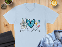 Load image into Gallery viewer, Light blue t-shirt with "peace love pharmacy" text and blue heart, pills.