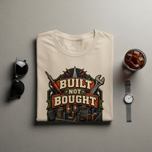 Load image into Gallery viewer, Cream t-shirt with "Built Not Bought" graphic featuring electronics and tools.