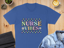 Load image into Gallery viewer, Blue t-shirt with colorful checkered text reading "NURSE VIBES" and floral accents.