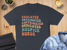 Load image into Gallery viewer, T-shirt with "Educated. Caffeinated. Dedicated. Hospice Nurse." text in colorful retro font.
