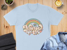 Load image into Gallery viewer, Light blue t-shirt with "Nurse Life" rainbow and syringe graphic.