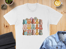Load image into Gallery viewer, White t-shirt with "NURSE NURSE NURSE" text in colorful, retro lettering.
