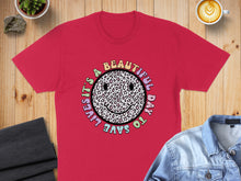 Load image into Gallery viewer, Red t-shirt with "It's a beautiful day to save lives" text around leopard print smiley face.