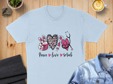 Load image into Gallery viewer, Peace love scrub graphic with stethoscope, heart, and syringe on a light blue t-shirt.