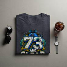 Load image into Gallery viewer, Dark grey t-shirt with a graphic featuring the number 73, a globe, and radio tower elements.