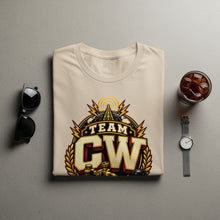 Load image into Gallery viewer, Tan t-shirt with "TEAM CW" logo featuring a globe and broadcast tower.